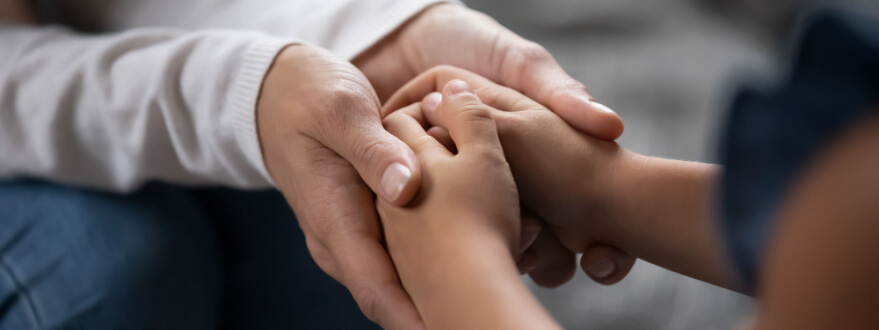 parent holding their child's hands