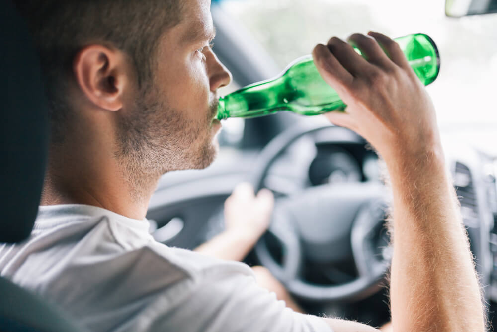 Driver drinking beer while driving.