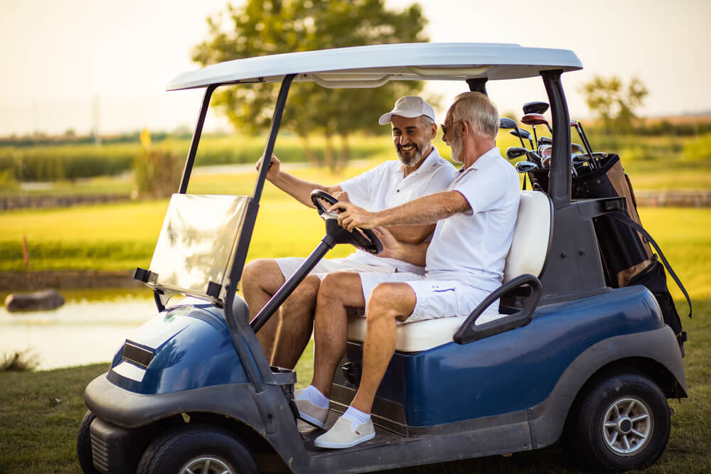 Senior driving golf cart.